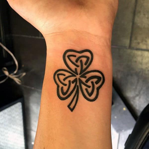Small tribal trinity shamrock wrist tattoo