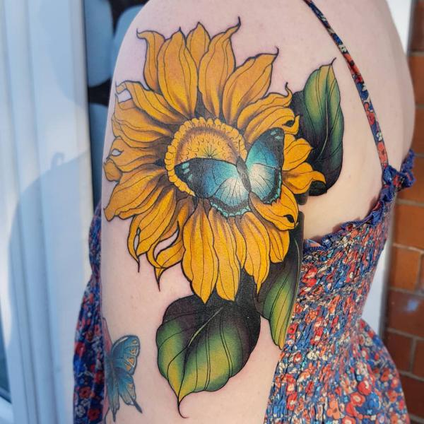 Sunflower and blue butterfly tattoo on shoulder
