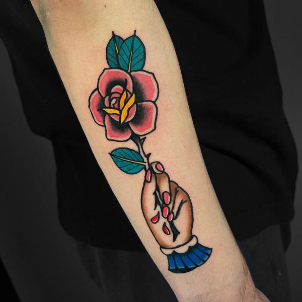 Traditional a hand holding a rose with thorns