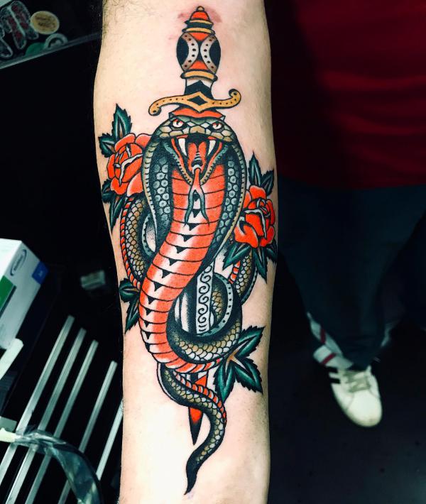 Traditional cobra enwinted with dagger and rose tattoo forearm