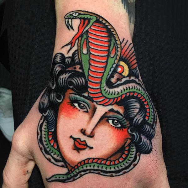 Traditional female face and cobra tattoo