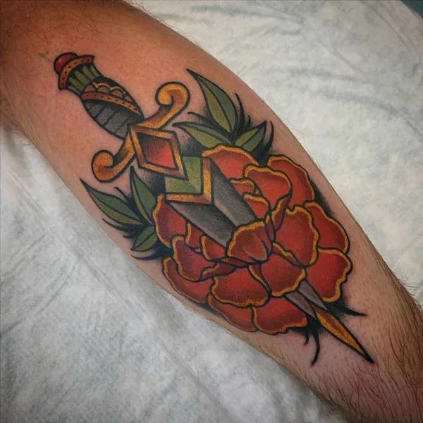 Traditional marigold and dagger tattoo