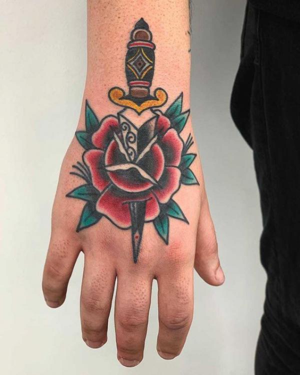 Traditional rose and dagger hand tattoo