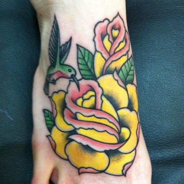 Traditional yellow rose and hummingbird foot tattoo