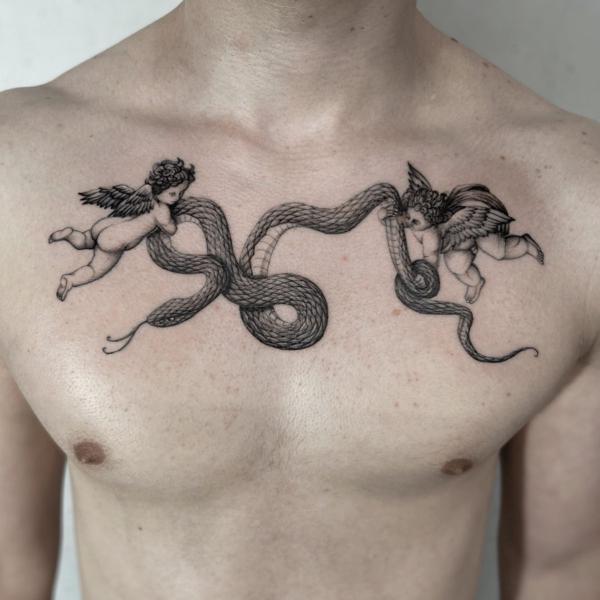 Two cherubs fighting with snake chest tattoo