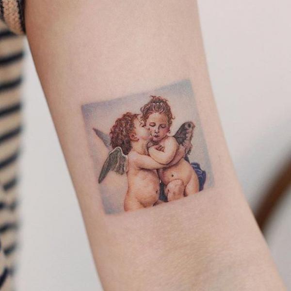 Two colored loving cherubs tattoo