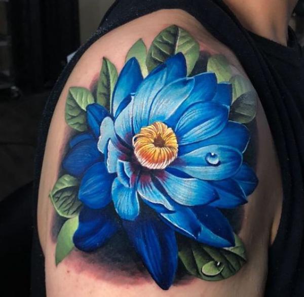 Vibrant blue lotus flower should cap tattoo