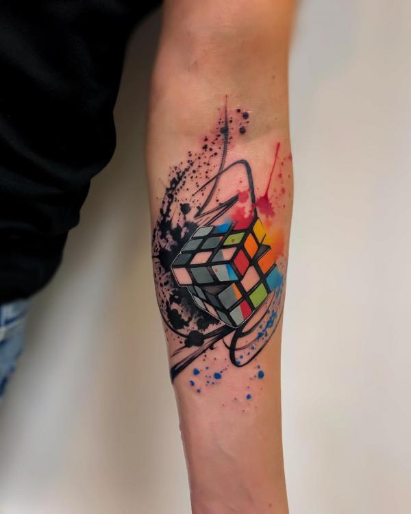 Watercolor Rubiks Cube tattoo on inner forearm