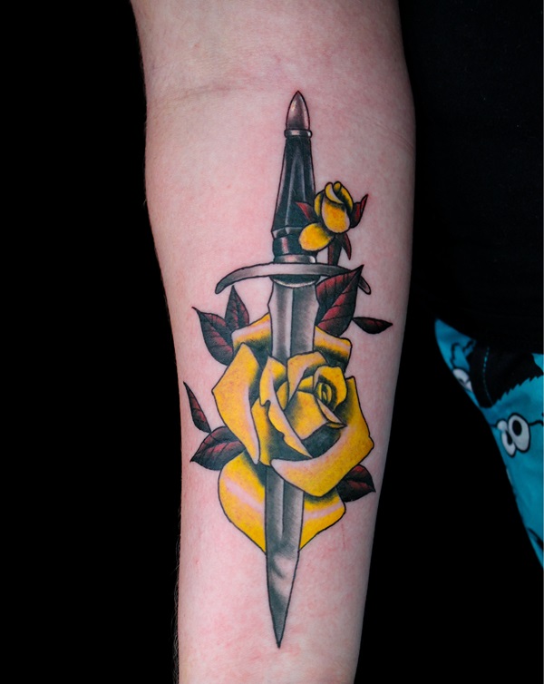 Yellow rose and dagger forearm tattoo