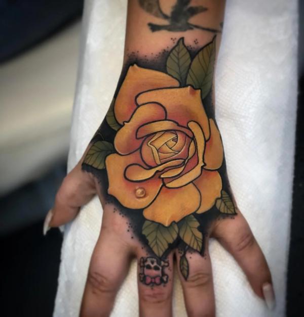 Yellow rose hand tattoo