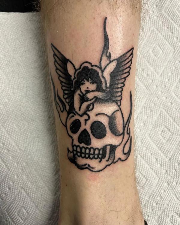 traditional black and white cherub and skull tattoo