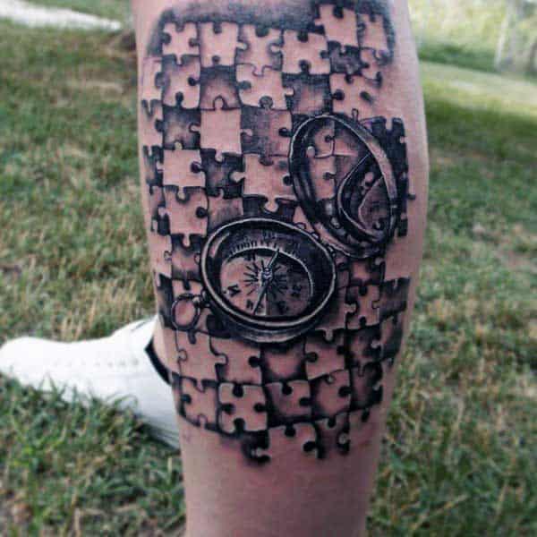 A compass in puzzle pieces tattoo