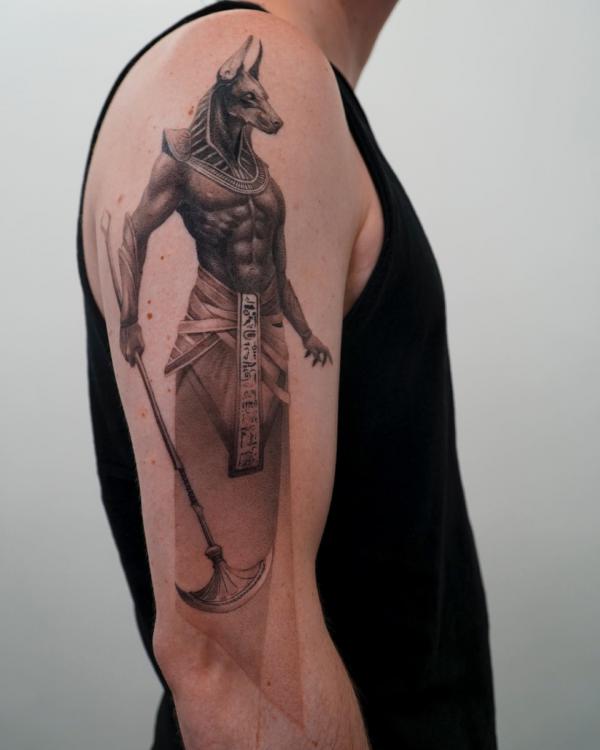 Anubis warrior holding a palm axe tattoo on arm