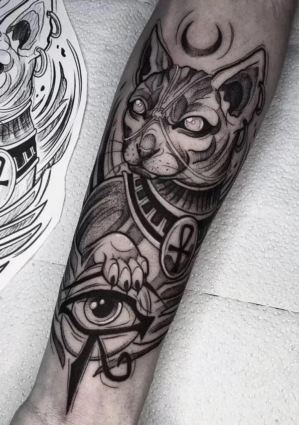 Bastet with Eye of Horus tattoo on forearm