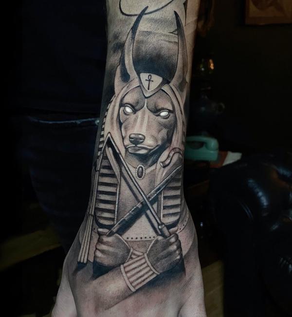 Black and grey Anubis holding scepter tattoo