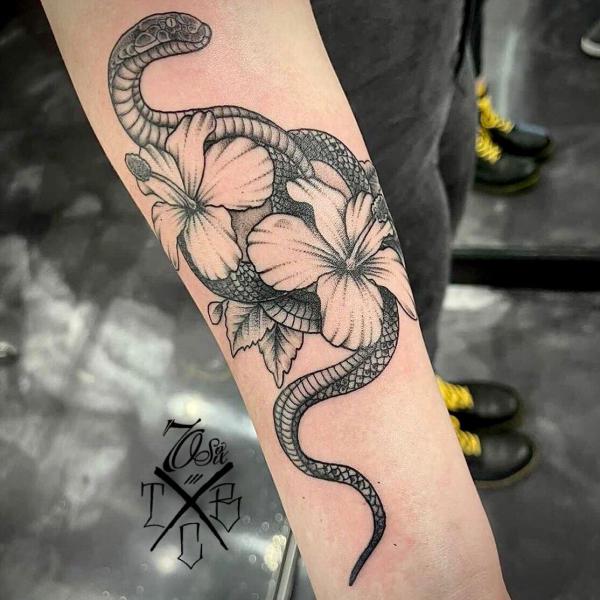 Black and grey hibiscus and snake forearm tattoo