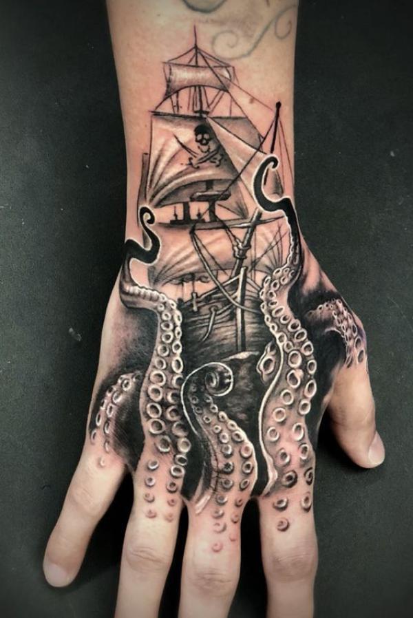 Black and grey kraken and pirate ship tattoo on hand