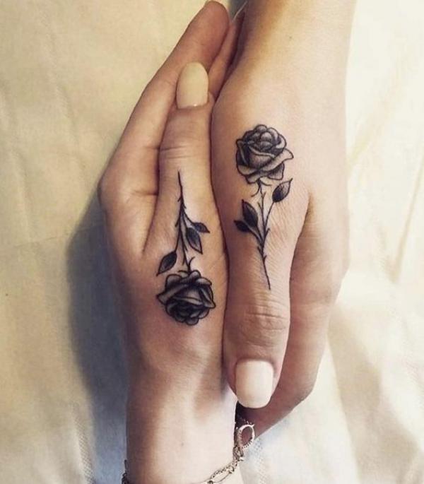 Black and grey rose tattoo on both thums