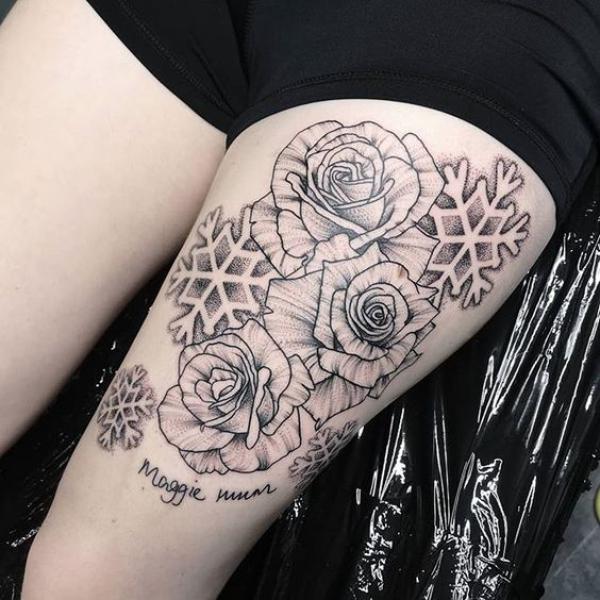 Black and grey snowflake and rose tattoo on thigh