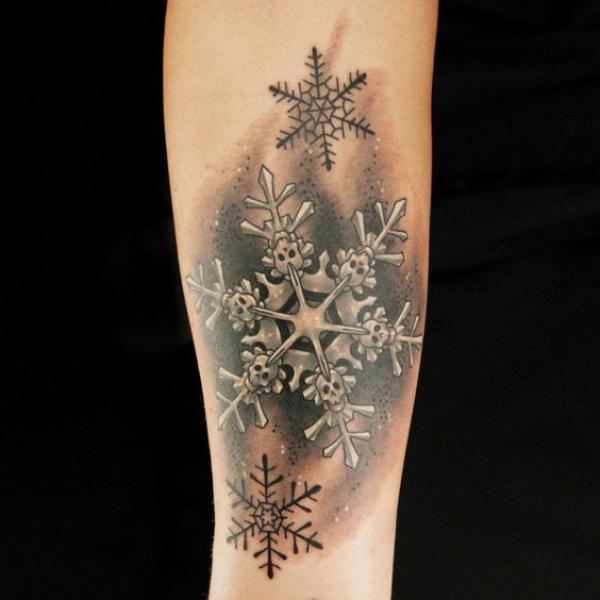 Black and grey snowflake forearm tattoo