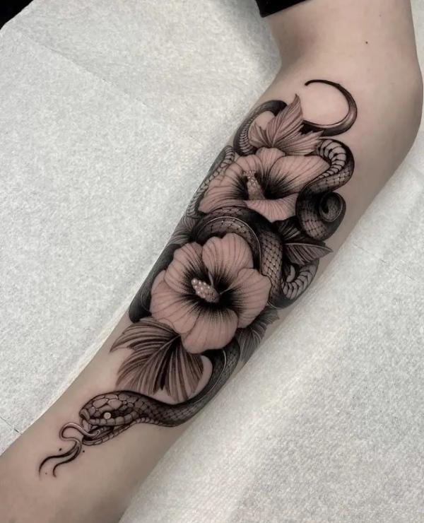 Black and white snake and hibiscus forearm tattoo