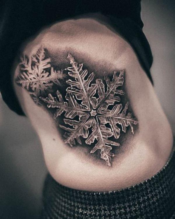 Black and white snowflake side tattoo