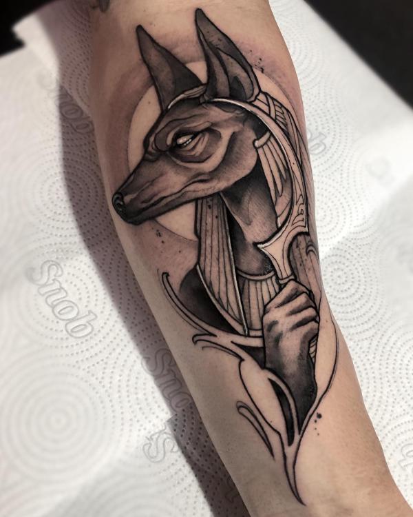 Black anf grey Anubis holding Khopesh tattoo