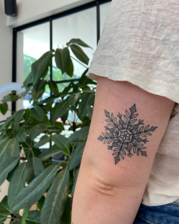 Black snowflake elbow tattoo