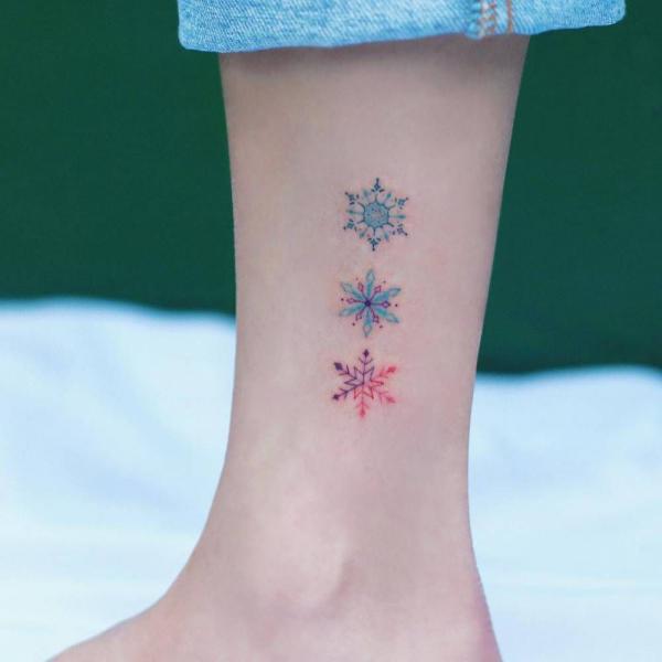 Blue and red feminine snowflake tattoo