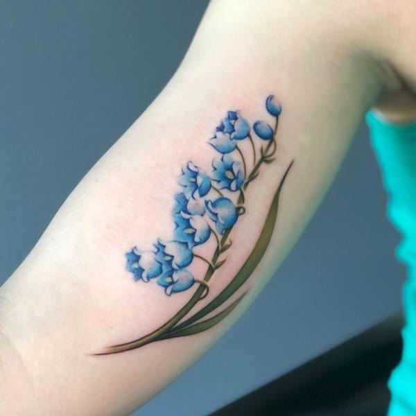 Blue lily of the valley floral watercolor tattoo on Bicep