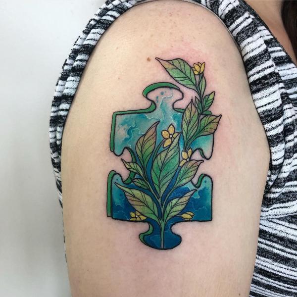 Botanical puzzle tattoo on upper arm