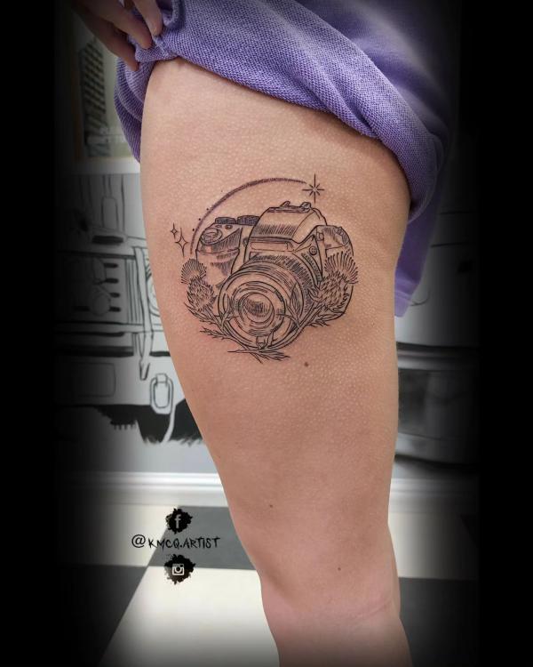 Camera with thistle and shooting star tattoo