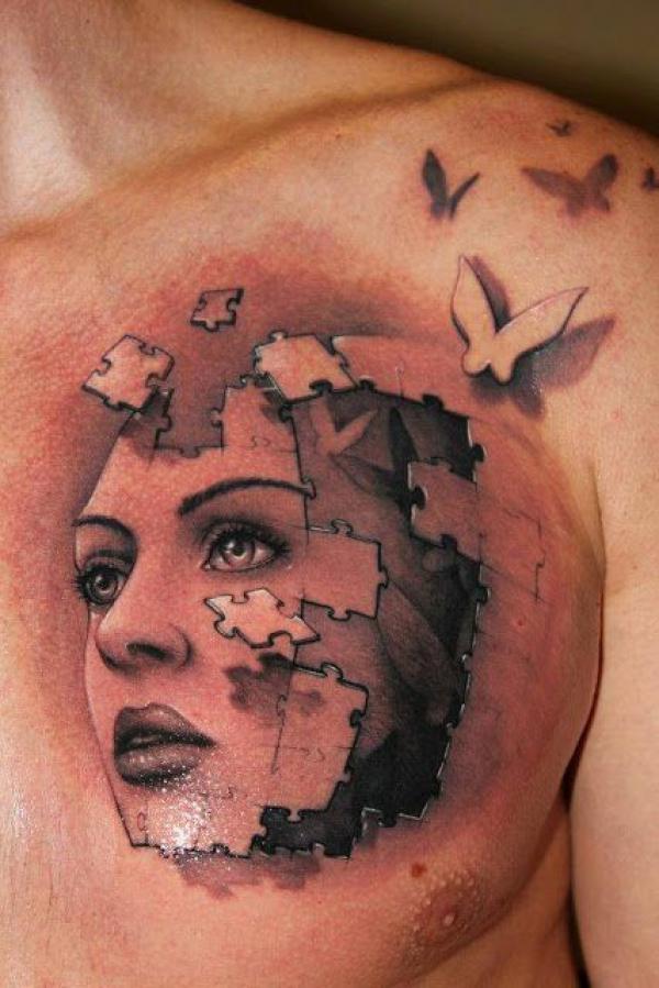 Female with puzzle face chest tattoo