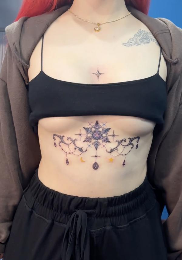 Feminine snowflake sternum tattoo