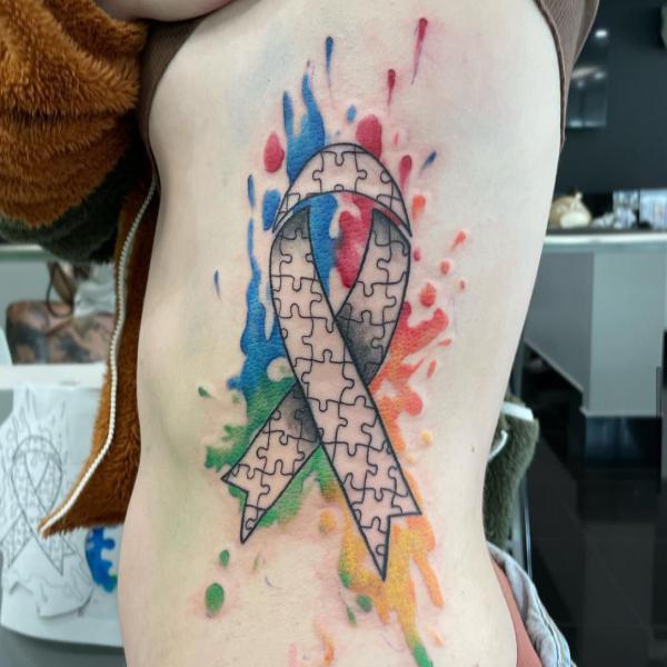 Fine line puzzle ribbon tattoo on watercolor backdrop
