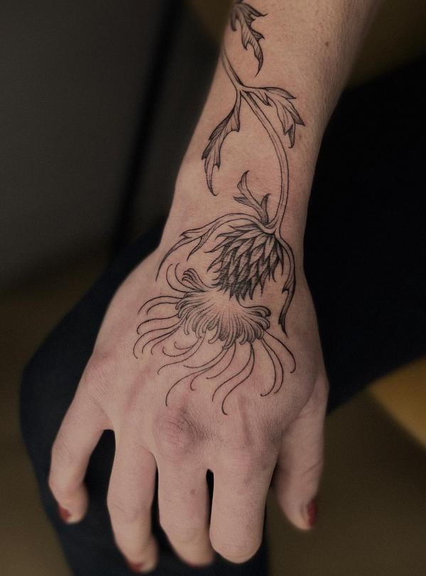 Fineline thistle hand tattoo
