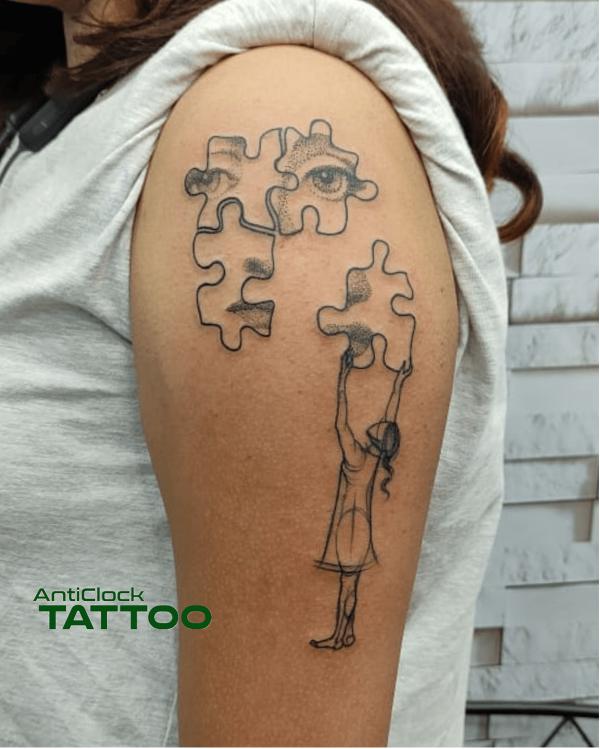Four puzzle pieces eyes and girl tattoo