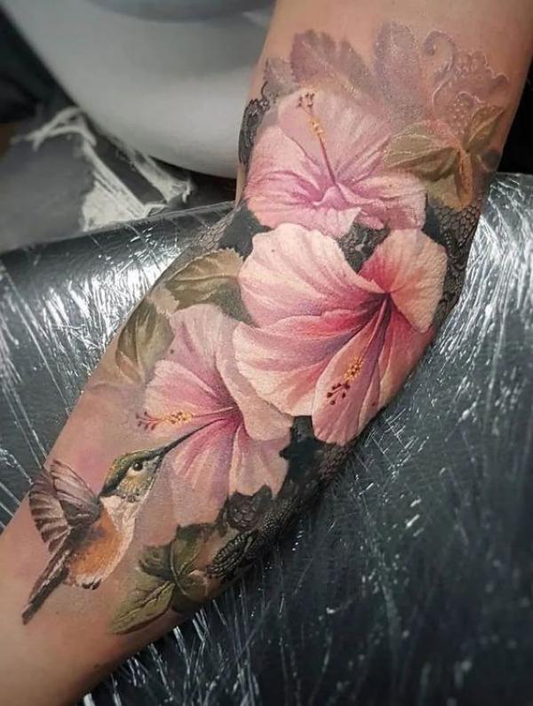 Hummingbird and light pink hibiscus tattoo