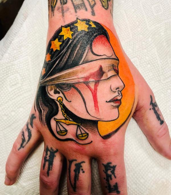 Lady with Scales of justice hand tattoo