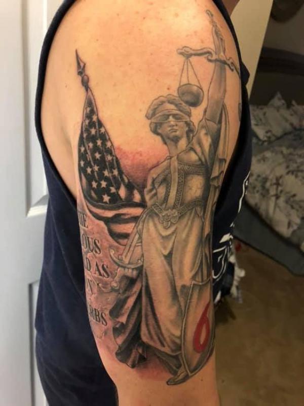 Lady with scales of justice and American flag tattoo