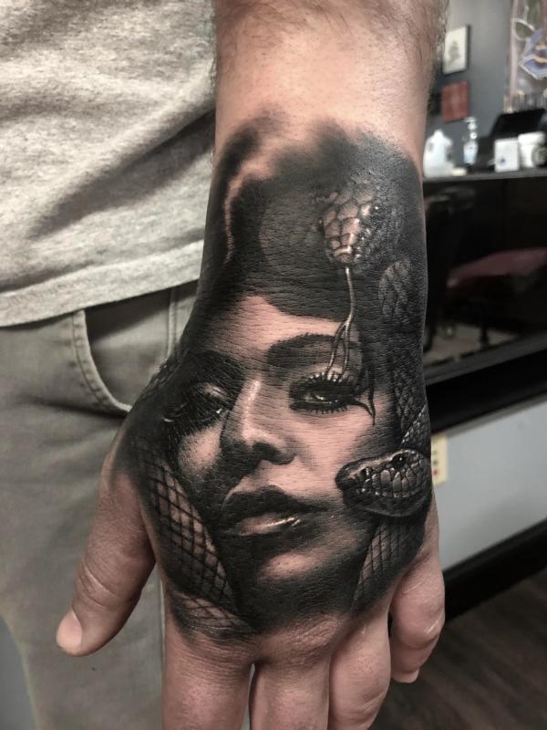 Medusa face with snakes tattoo on hand