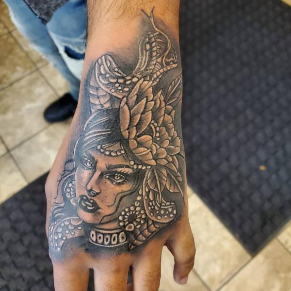 Medusa with flower and snake hand tattoo