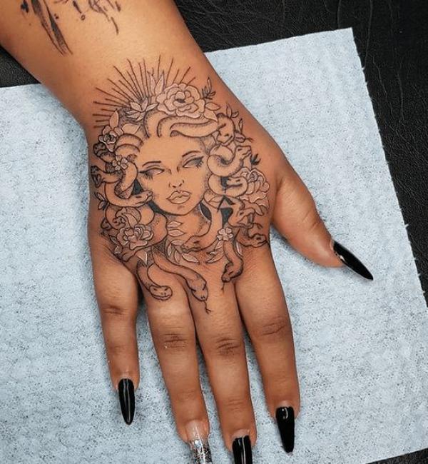 Medusa with snake and flower hand tattoo