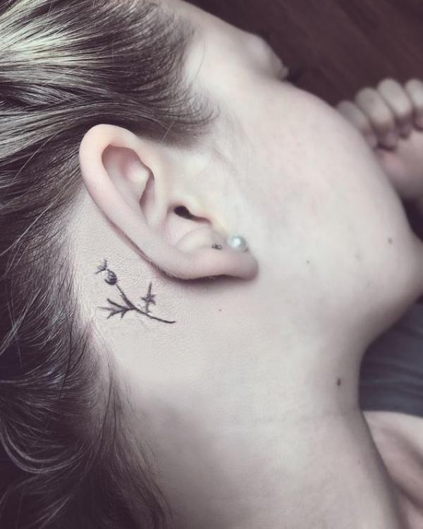 Minimalist thistle tattoo behind ear