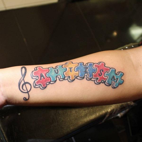 Music staff and puzzles forearm tattoo