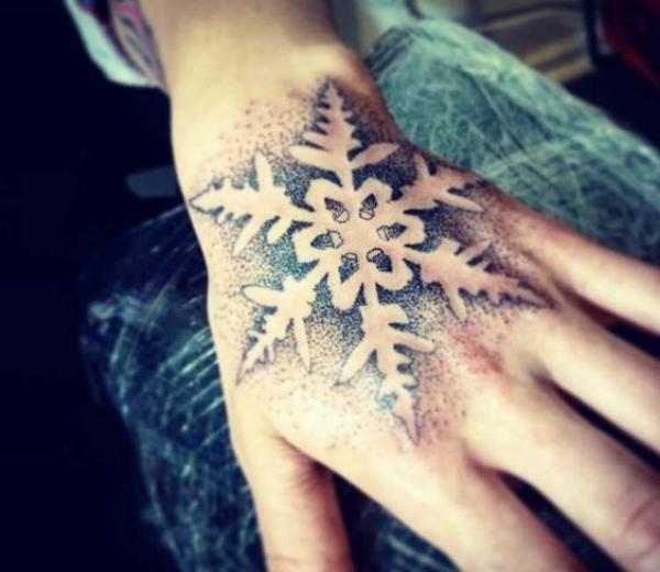 Negative space snowflake hand tattoo