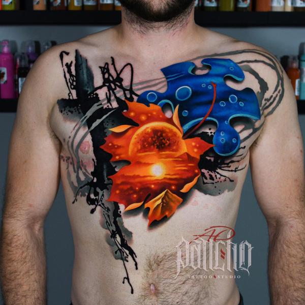 Puzzle and maple leaf chest tattoo