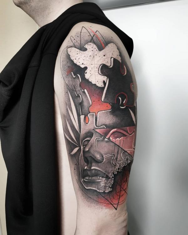 Puzzle face and bird silhouette tattoo