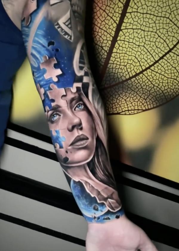 Puzzle face forearm tattoo