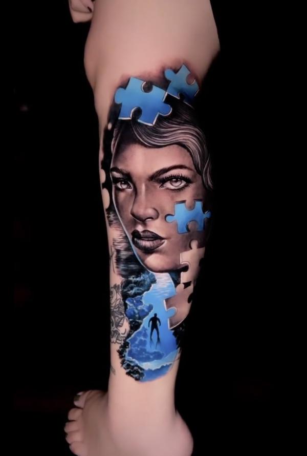 Puzzle face lower leg tattoo